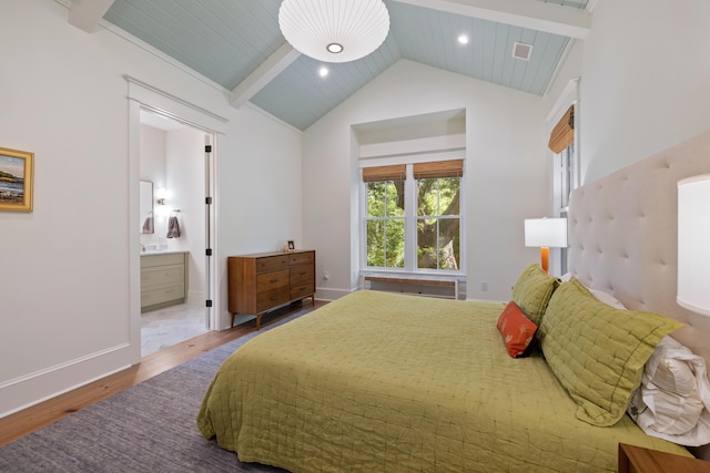 bedroom featuring high vaulted ceiling, baseboards, wood finished floors, ensuite bathroom, and beamed ceiling