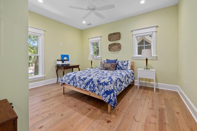 bedroom with multiple windows, wood-type flooring, and recessed lighting