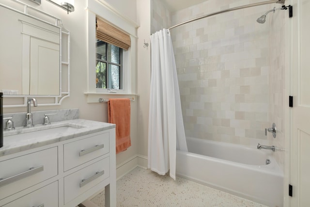 bathroom with baseboards, shower / bath combination with curtain, and vanity