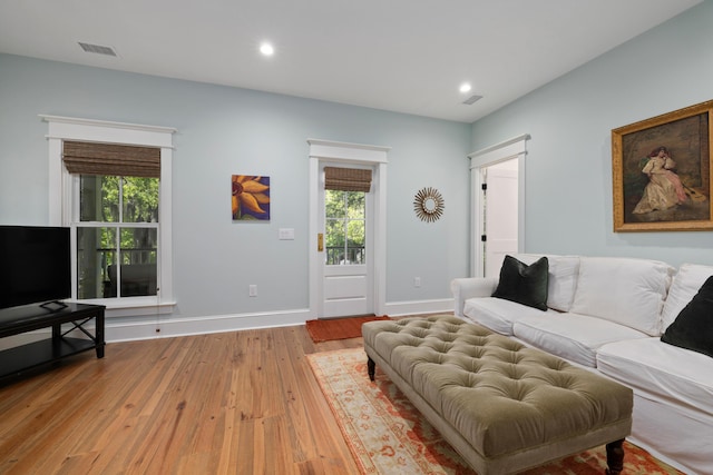 living room with plenty of natural light, recessed lighting, light wood finished floors, and baseboards