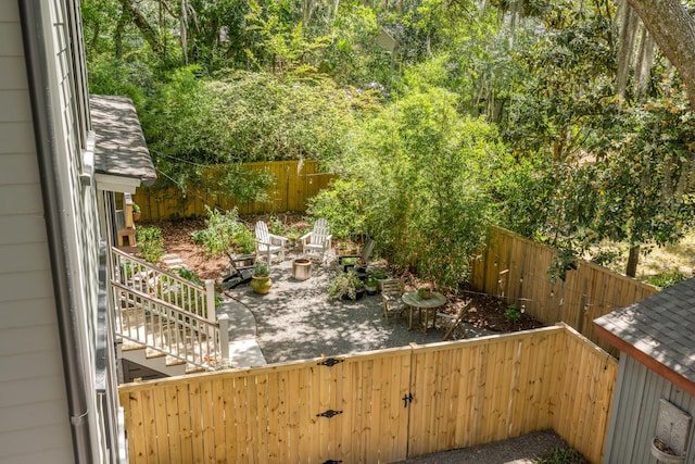 view of yard featuring stairs, a fenced backyard, and a patio area