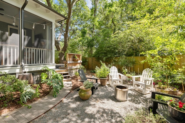 view of yard with a sunroom, a fenced backyard, and a patio area