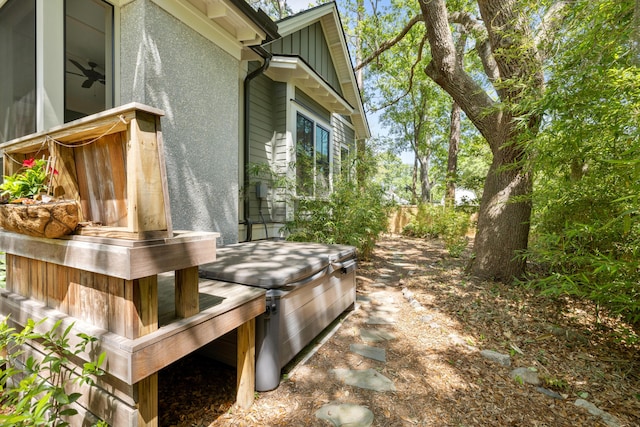 view of side of property featuring fence, board and batten siding, and stucco siding