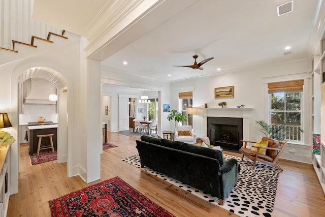living area featuring visible vents, crown molding, and a wealth of natural light