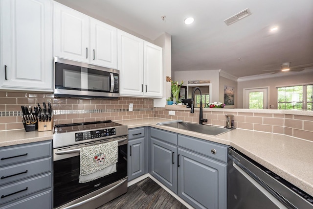 1121 Basildon Rd, Mount Pleasant, SC 29466 - kitchen featuring stainless steel appliances, gray cabinets, decorative backsplash, light countertops, and crown molding