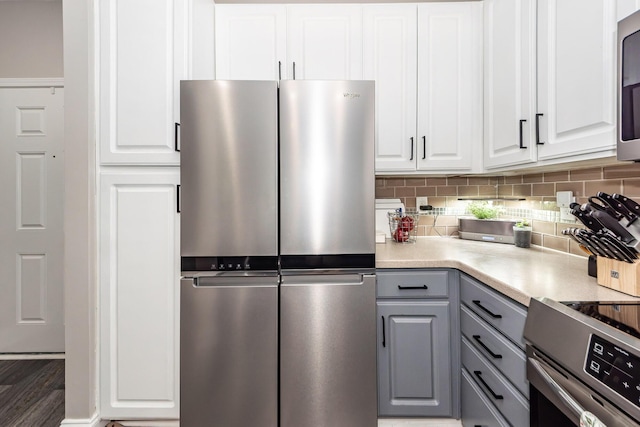 1121 Basildon Rd, Mount Pleasant, SC 29466 - kitchen with stainless steel appliances, gray cabinetry, tasteful backsplash, white cabinets, and light countertops