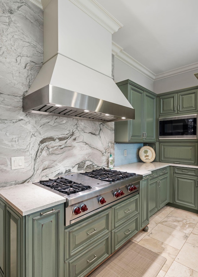 kitchen featuring premium range hood, built in microwave, crown molding, green cabinetry, and stainless steel gas stovetop