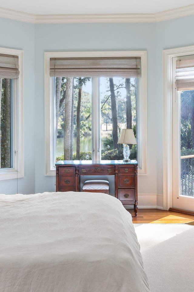 bedroom with ornamental molding and light wood-type flooring