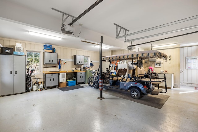 garage with a garage door opener and a workshop area