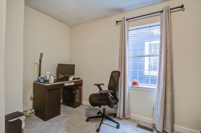 carpeted office space featuring a textured ceiling