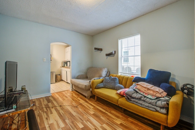 living room featuring light hardwood / wood-style flooring and a textured ceiling