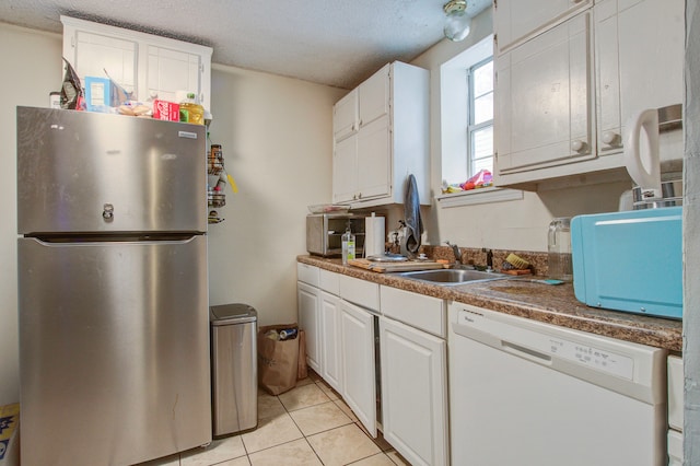 kitchen with stainless steel fridge, white cabinetry, a textured ceiling, and dishwasher