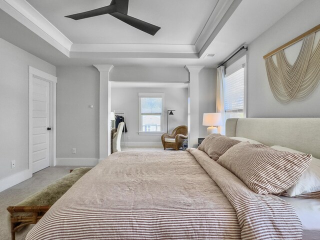 bedroom featuring decorative columns, carpet, baseboards, and a raised ceiling