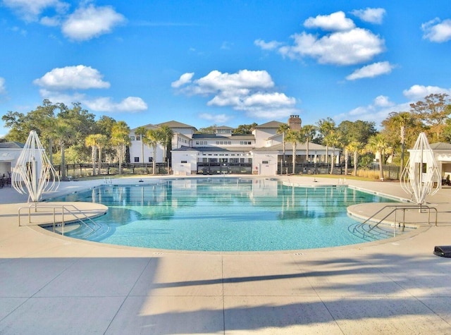 pool with a patio and fence