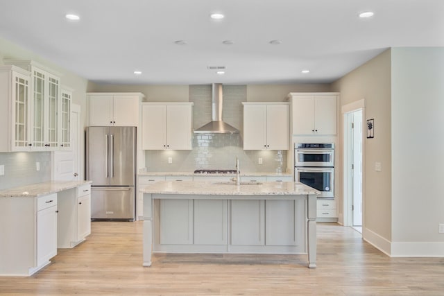 357 Parish Farms Dr, Summerville, SC 29486 - kitchen with stainless steel appliances, wall chimney range hood, backsplash, light wood-style flooring, and white cabinets