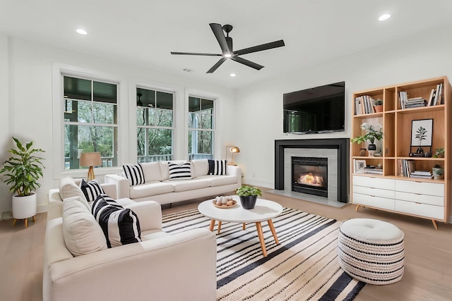 living room featuring a healthy amount of sunlight, ceiling fan, and light hardwood / wood-style flooring