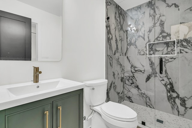 bathroom with vanity, toilet, and tiled shower