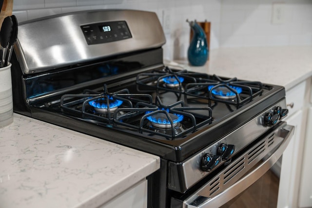 701 Squire Pope Rd, Summerville, SC 29486 - kitchen view of stainless steel range with gas stovetop, tasteful backsplash, and light stone counters