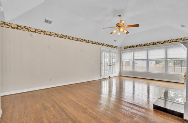 empty room featuring french doors, light wood-type flooring, vaulted ceiling, and ceiling fan