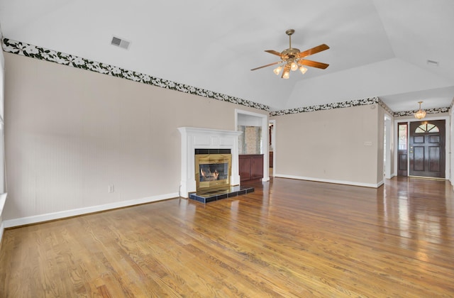 unfurnished living room featuring hardwood / wood-style floors, ceiling fan, lofted ceiling, and a fireplace