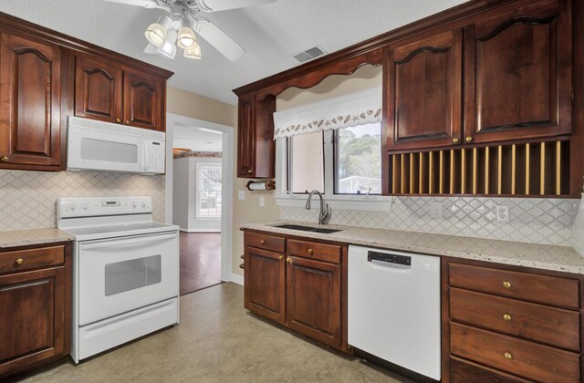 kitchen featuring white appliances, sink, ceiling fan, light stone countertops, and tasteful backsplash