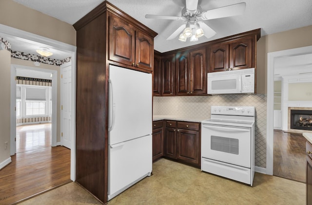 kitchen featuring dark brown cabinets, white appliances, light hardwood / wood-style floors, and ceiling fan