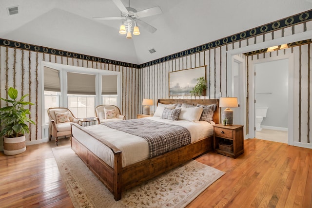 bedroom with ceiling fan, ensuite bathroom, light hardwood / wood-style floors, and lofted ceiling