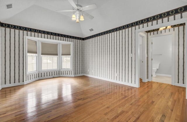 spare room with hardwood / wood-style floors, ceiling fan, and lofted ceiling