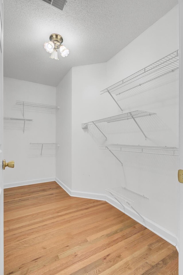 walk in closet with hardwood / wood-style floors