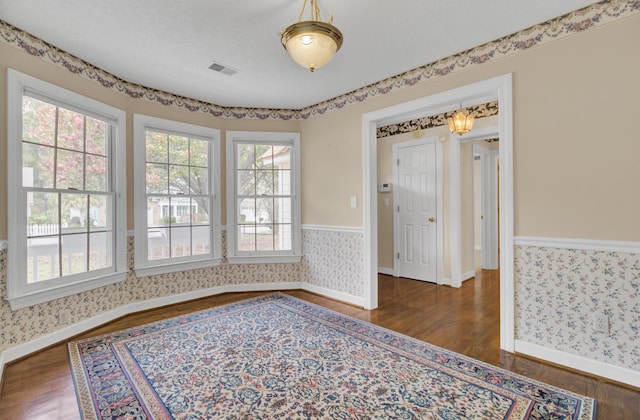 unfurnished room with dark hardwood / wood-style flooring and a textured ceiling