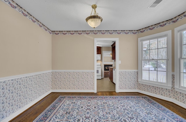 unfurnished room featuring dark wood-type flooring and a textured ceiling