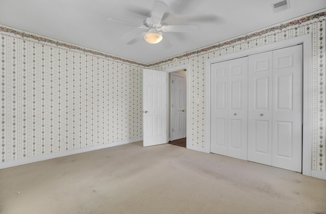 unfurnished bedroom featuring ceiling fan, a closet, and light colored carpet