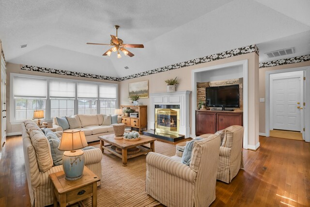 living room with a textured ceiling, ceiling fan, wood-type flooring, and lofted ceiling