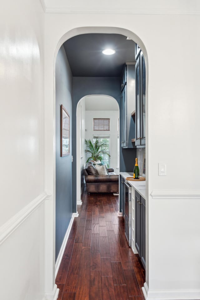 corridor with dark hardwood / wood-style flooring and ornamental molding