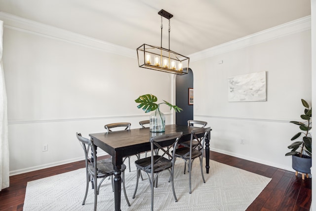 dining room with ornamental molding and dark wood-type flooring