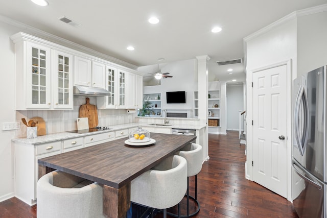 kitchen with dark hardwood / wood-style floors, sink, white cabinets, stainless steel fridge, and black electric stovetop