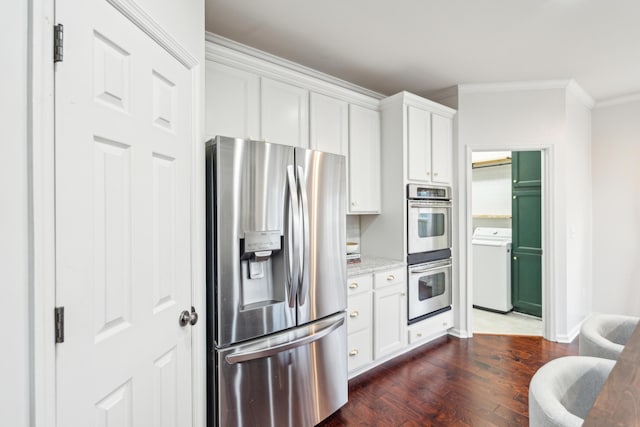 kitchen with appliances with stainless steel finishes, white cabinetry, dark hardwood / wood-style floors, light stone counters, and washer / dryer