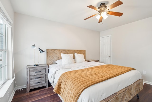 bedroom with dark hardwood / wood-style flooring and ceiling fan