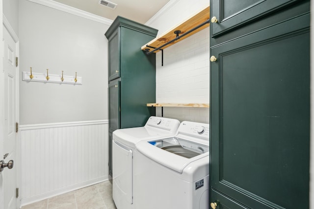 laundry room with cabinets, washing machine and dryer, light tile patterned floors, and crown molding