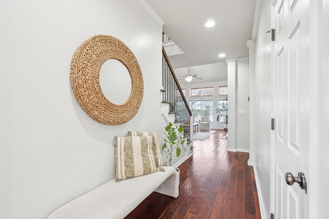 hallway with decorative columns, ornamental molding, and dark hardwood / wood-style floors