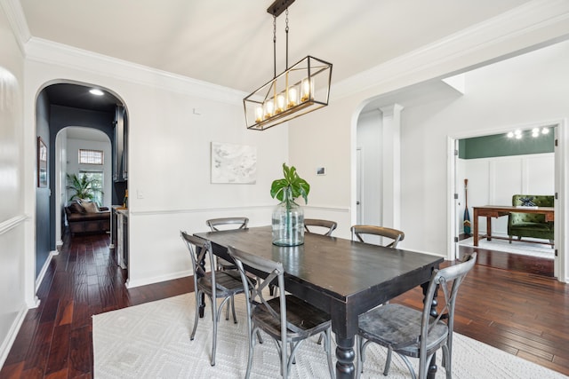 dining space featuring ornamental molding, dark hardwood / wood-style floors, and decorative columns