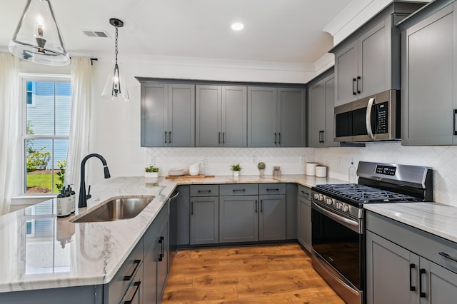 3806 Grateful Rd, North Charleston, SC 29420 - kitchen with appliances with stainless steel finishes, a sink, gray cabinetry, light wood-style floors, and a peninsula