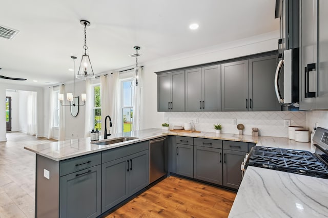 3806 Grateful Rd, North Charleston, SC 29420 - kitchen featuring a sink, appliances with stainless steel finishes, a peninsula, gray cabinets, and tasteful backsplash