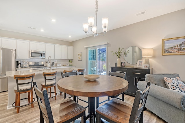 dining space with light wood-style floors, visible vents, a chandelier, and recessed lighting