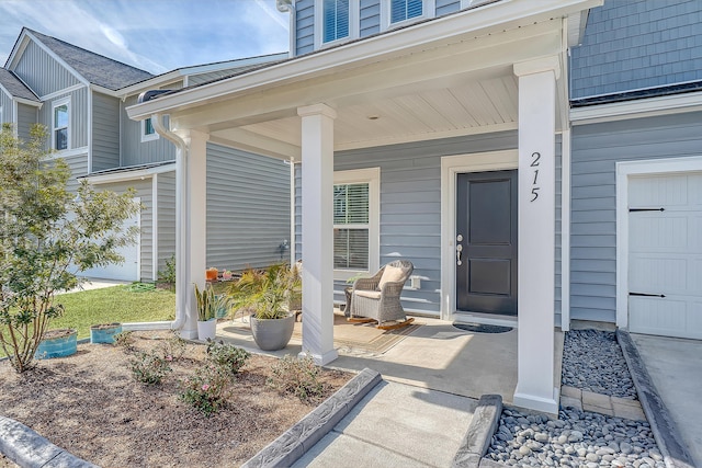 view of exterior entry with covered porch and a garage