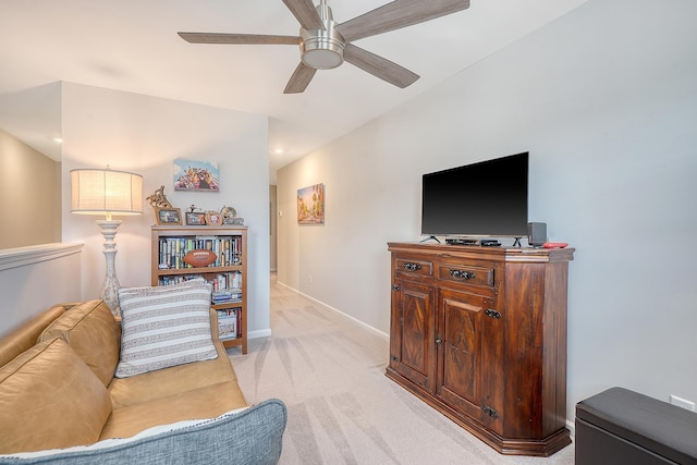 living room featuring ceiling fan, baseboards, and light colored carpet