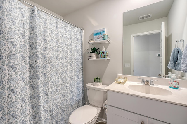 bathroom featuring toilet, a shower with shower curtain, vanity, and visible vents