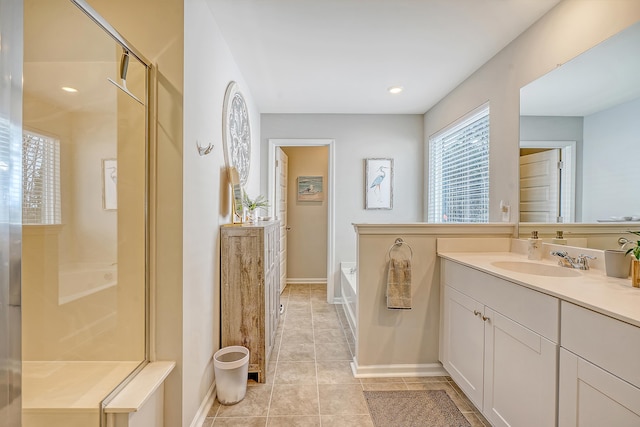 bathroom with tile patterned flooring, a shower with shower door, a garden tub, vanity, and baseboards