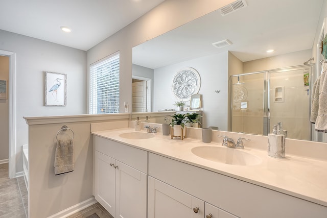 full bath featuring a stall shower, a sink, and visible vents