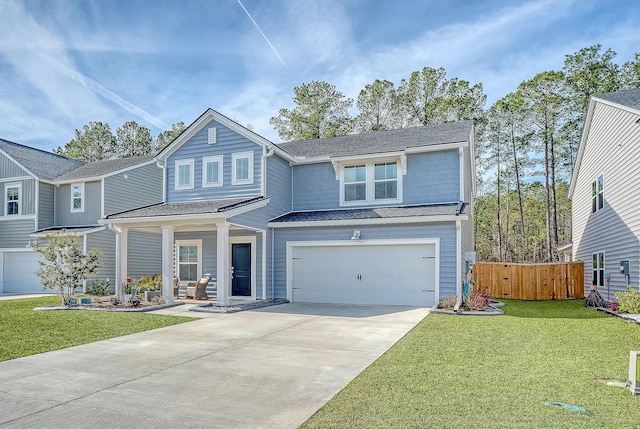 traditional-style home with a garage, driveway, a front lawn, and fence